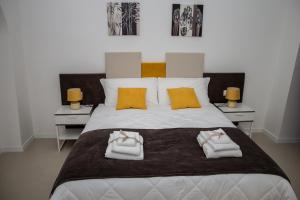 格拉维纳普利亚LA CIVITA B&B的卧室配有带毛巾的大型白色床