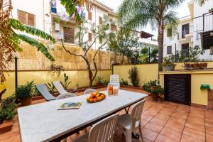 圣夫拉维亚Solemar Sicilia - Casa Maria的庭院配有桌椅和橙子