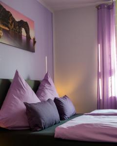 贝恩堡Zimmervermietung Hebenstreit的一间卧室配有一张带紫色和白色枕头的床