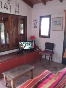 阿瓜德奥罗Casa de Campo Udea的客厅配有电视、桌子和椅子