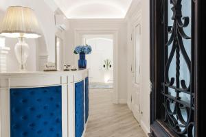 罗马扎纳德里住宿的走廊上设有蓝色和白色的房间,配有桌子