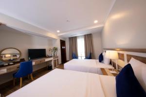 胡志明市Sabina Boutique Hotel 2的酒店客房设有两张床和电视。