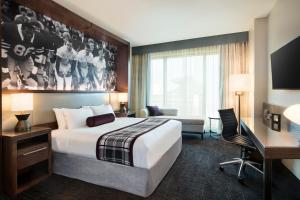 大学城Texas A&M Hotel and Conference Center的酒店客房设有一张大床和一张书桌。