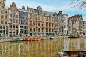 阿姆斯特丹Luxury Canal Suite De Heren的城市的运河,里面有建筑物和船只