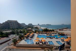 拉斯阿尔卡麦City Stay Beach Hotel Apartments - Marjan Island的享有带遮阳伞的游泳池和大海的顶部景致