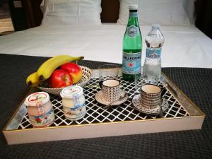 维罗纳OFFICINA TESINI Guest Rooms Verona的托盘,包括水果和两瓶水杯和饮料