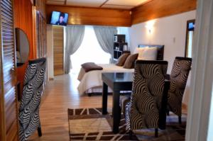SasolburgAzrielle Guesthouse的卧室配有一张床和一张桌子及椅子