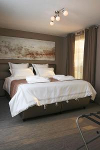克诺克－海斯特B2B Luxury Apartments Hotel Services Included的一间卧室设有两张带白色床单的床和窗户。