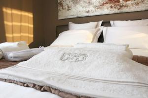 克诺克－海斯特B2B Luxury Apartments Hotel Services Included的一张带白色毯子和枕头的床