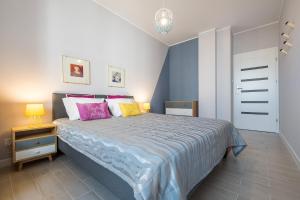 华沙Raya Mansion Warsaw的一间卧室配有带粉色和黄色枕头的床