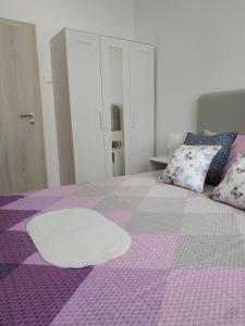 扎达尔Holiday Home Arbanase的一间卧室配有一张紫色床,上面有一张白色的桌子