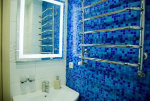 别列戈沃Sahara的蓝色瓷砖浴室设有水槽和镜子