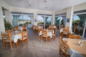 凯法洛斯赫尔墨斯酒店的餐厅设有桌椅和窗户。