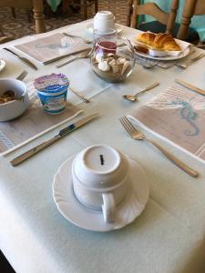 费拉约港阿葵玛莉娜酒店的一张桌子,上面有白杯和盘子
