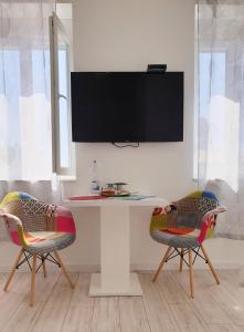 扎达尔Vila Siega的一张桌子、两把椅子和墙上的电视