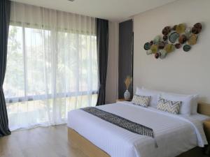 拉迈CHUZ Villas Samui SHA Plus的一间卧室设有一张大床和一个大窗户