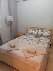 尼亚米卡尼奥纳Tassos的一间卧室配有一张床,上面有两条毛巾