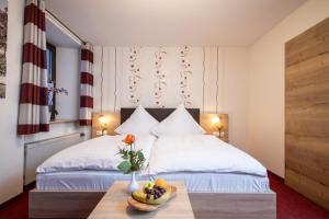 哈尔堡斯特劳森餐厅酒店的一间卧室设有两张床,桌子上放着一碗水果