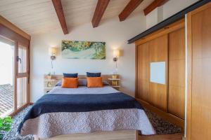 坎加斯德穆拉索Casa do Outeiro的一间卧室配有一张带橙色枕头的大床