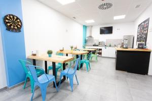 塔里法Ohana Tarifa Hostel的一间配备有桌子和蓝色椅子的用餐室