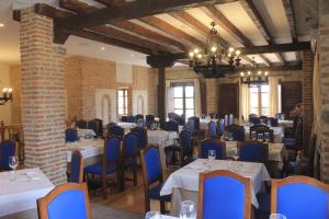 阿维拉Vettonia的用餐室配有白色的桌子和蓝色的椅子