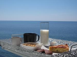 迪亚曼特Sul Mare B&B的一张早餐桌,上面有一盘食物和一杯牛奶