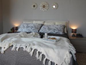 迪亚曼特Sul Mare B&B的一张带白色毯子和两张蜡烛的床