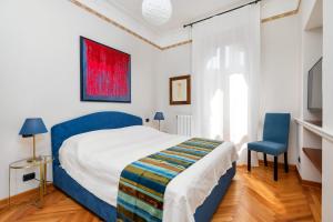 威尼斯San Zaccaria Apartment的一间卧室配有一张床和一张蓝色椅子