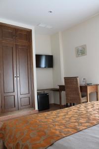科尼尔-德拉弗龙特拉阿尔玛德拉巴科尼尔酒店的一间卧室配有一张床、一张桌子和一张书桌