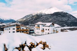 皮茨河谷阿兹尔Pitzis Kinderhotel - Family Only的雪地中的度假胜地,背景是一座山
