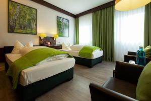 拜罗伊特金色赫西酒店的酒店客房,配有两张带绿床单的床