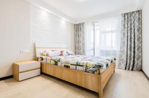 基辅ARTAL Apartment on Obolonsky avenue 16a的一间卧室设有一张床和一个窗口