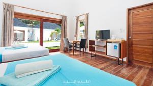 邦劳邦劳岛屿世界度假村的一间卧室配有两张床和一张书桌及电视