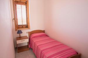 夏卡Case Vacanza Renella 3 beds: Balcony, wifi, self-catering, 200mt from the sea的一间小卧室,配有床和窗户