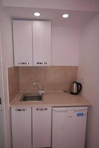 艾斯普罗瓦塔Alexandros Studios的厨房配有白色橱柜和水槽