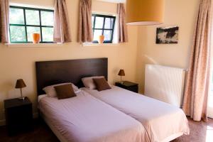 Westervoort大百凡克住宿加早餐酒店的一间卧室配有一张带白色床单和窗户的床。