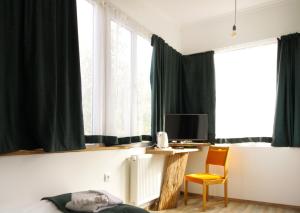 阿哈尔齐赫Insomnia的一间卧室配有绿色窗帘、书桌和椅子