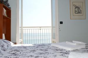 莱圭利亚Appartamento "Abbracciando il Mare"的一间卧室设有一张床,享有海景