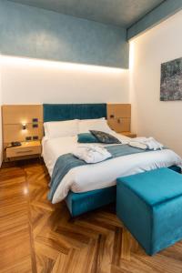特拉尼Palazzo Filisio - Regia Restaurant的一间卧室配有一张大床和蓝色脚凳