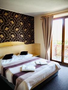 Fryšava优卢布酒店的一间卧室设有一张大床和一个窗户。
