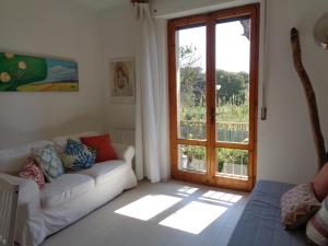 奎尔西亚内拉La casa di Nina的带沙发和滑动玻璃门的客厅