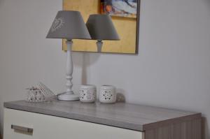 利扎诺House Le Fontanelle的一张桌子,上面有两盏灯和两杯杯子