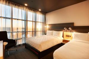 卡尔加里Alt Hotel Calgary East Village的酒店客房设有两张床和窗户。