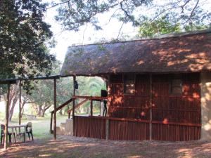 ManguziKosi Bay Casitas的茅草屋顶和长凳的小建筑