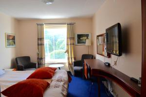 乌德瓦拉滨江酒店的配有一张床和一台平面电视的酒店客房