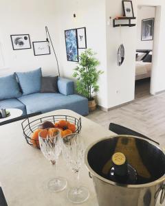 维斯EllaVis Apartments的厨房配有带酒杯和一碗橘子的桌子