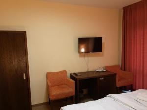 塞内奇贾尼大都会酒店的酒店客房设有一张床、一张书桌和一台电视机。