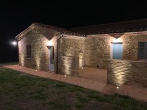 蒙塔尔奇诺Cordella In Valdorcia Truffle and Olive Oil Resort的夜晚有灯的石头房子