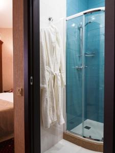 敖德萨ArcadiaSky的浴室配有带浴袍的玻璃淋浴间