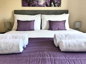 滨海韦斯顿Liberty Locking Castle的一间卧室配有一张大床,提供紫色床单和枕头